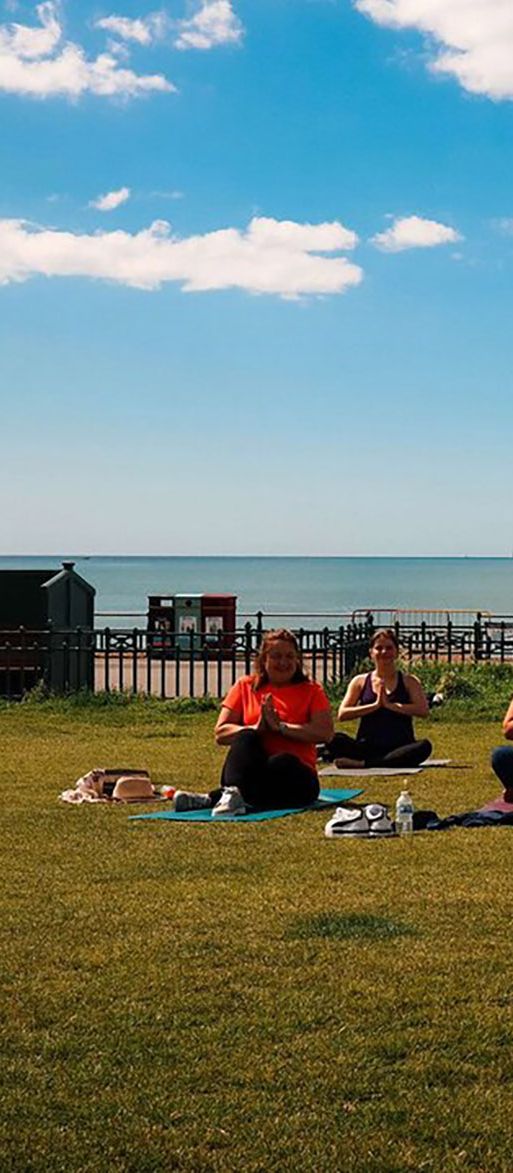 Outdoor yoga class taking place on the Brighton seafront for wellness hen dos