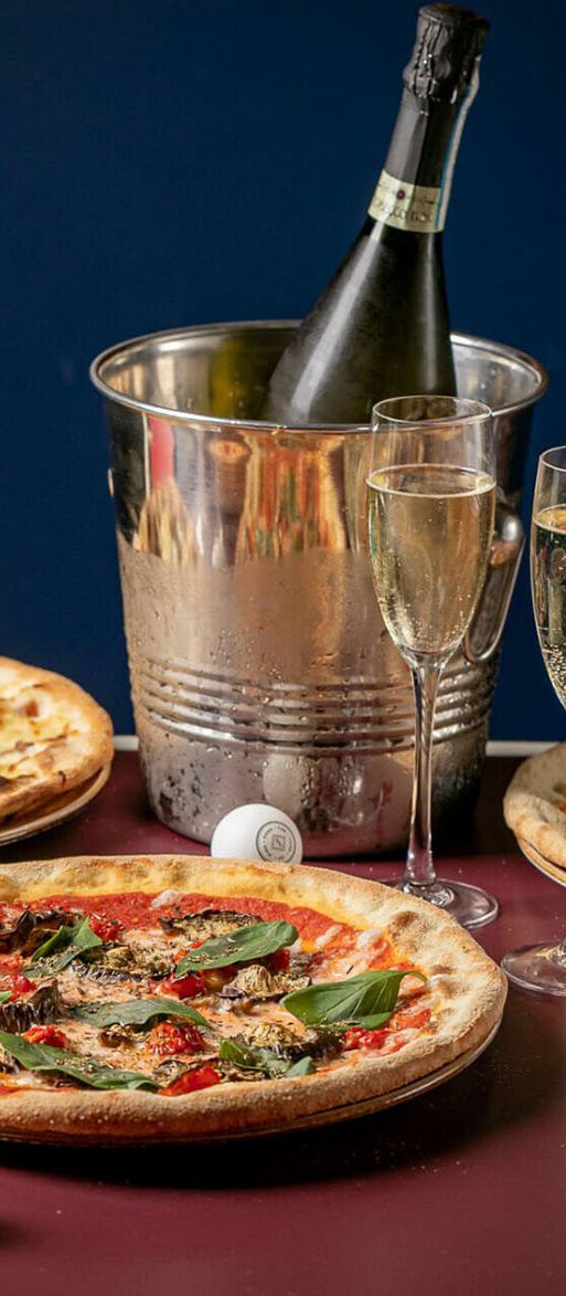 Pizzas, prosecco and ping pong balls on table for Bounce bottomless brunch 