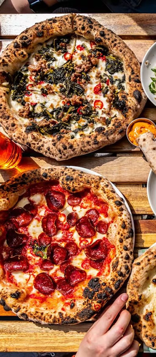 Table of pizzas and cocktails at the Pizza Pilgrims Liverpool Street bottomless brunch