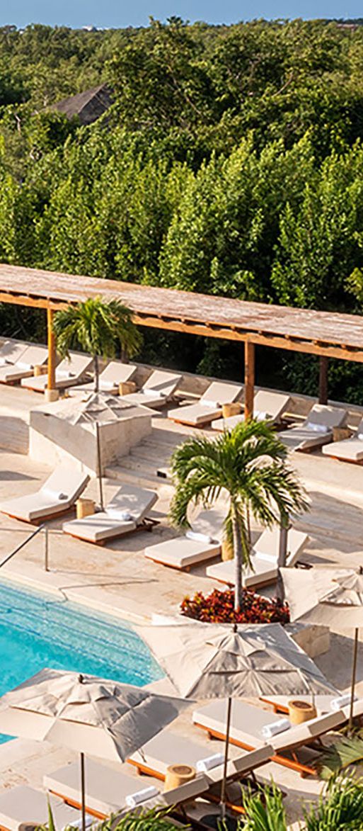 Pool and sunloungers with view of sea at Fairmont Mayakoba, Mexico honeymoon destination in Riviera Maya
