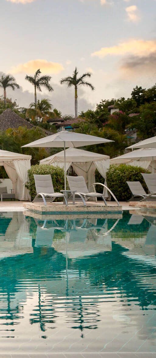 Couple relaxing by the pool at Sandals Grenada, an adults-only all-inclusive Caribbean honeymoon resort
