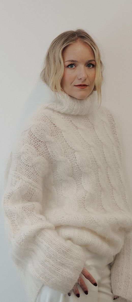 Hermione Olivia, standing all in white against a white wall