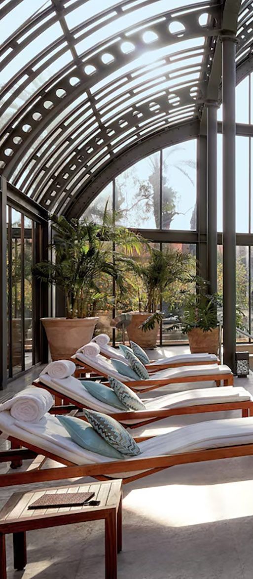 Greenhouse style pool area with sunloungers at riad minimoon hotel in Marrakech