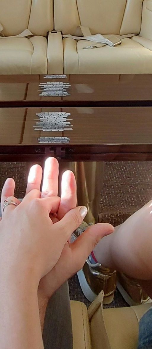 Couple holding hands on luxury 1st class honeymoon flight