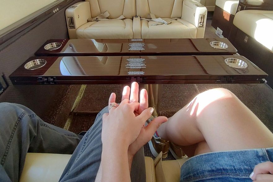Couple holding hands on luxury 1st class honeymoon flight