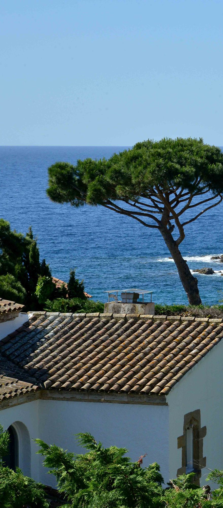 Historic Senya Blanca Loggia overlooking the Mediterranean Sea on the Costa Brava, surrounded by pine trees and landscaped gardens beside Hostal de La Gavina.