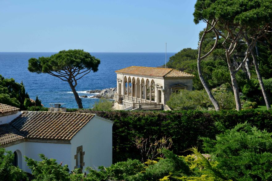 Historic Senya Blanca Loggia overlooking the Mediterranean Sea on the Costa Brava, surrounded by pine trees and landscaped gardens beside Hostal de La Gavina.