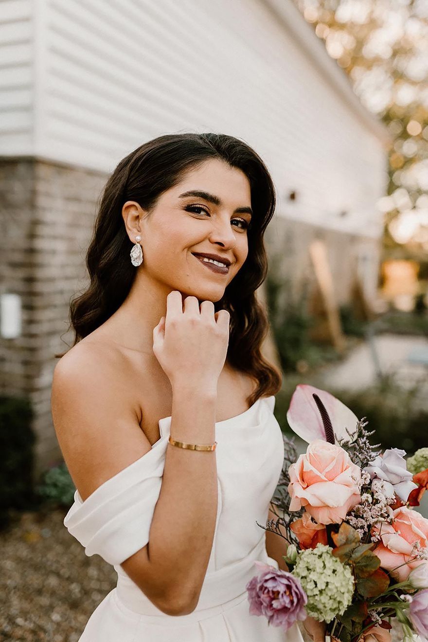 Bride with dark lipstick and gold eyeshadow with glowy skin