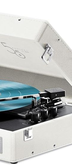 White portable suitcase-style record player with the lid open, playing a translucent blue vinyl record. The turntable features built-in front speakers, a carrying handle, and retro-inspired design details
