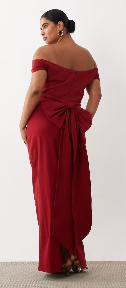 Rear view of a woman in a red off-the-shoulder maxi dress with a large bow detail at the back